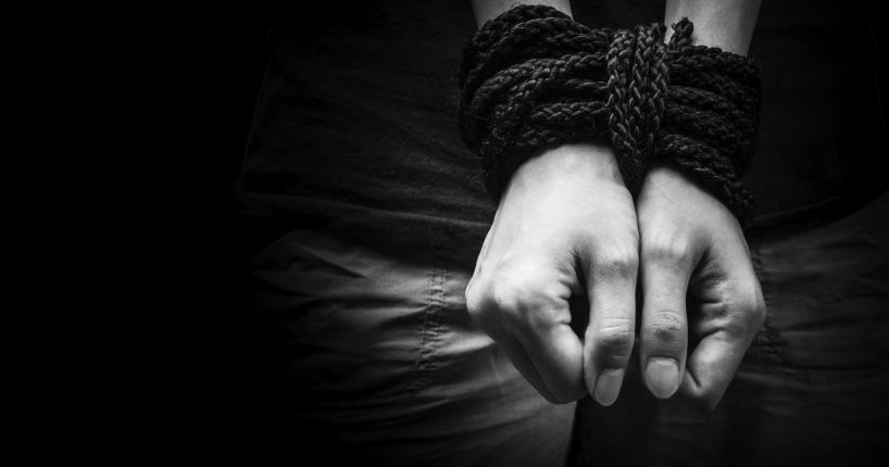 Hands of a missing kidnapped, abused, hostage, victim woman tied up with rope in emotional stress and pain, afraid, restricted, trapped, call for help, struggle, terrified, locked in a cage cell.